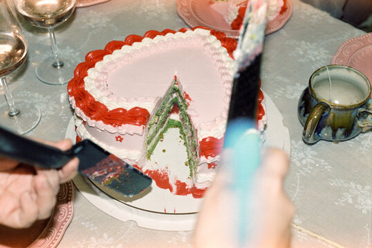 Heart-shaped cake with green layers being served  
