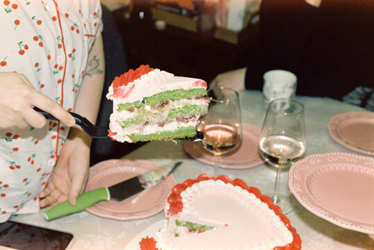 Serving a slice of heart-shaped cake at a birthday celebration  

