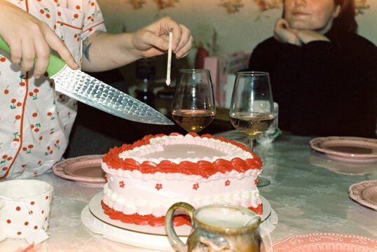 Serving a slice of heart-shaped cake at a birthday celebration  

