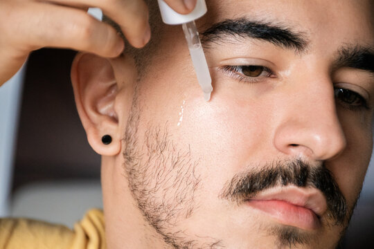 Skincare Routine for Men Using Dropper Serum in Cozy Setting