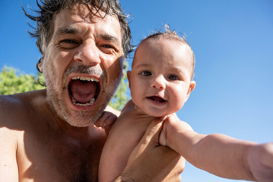 Man And Baby Making Faces At Camera Outdoors
