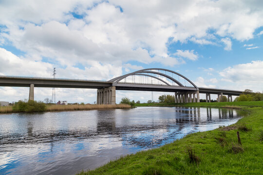 Highway bridge spanning the St&ouml;r River near Itzehoe, Schleswig-Holstein, Germany, under blue sky and spring landscape.