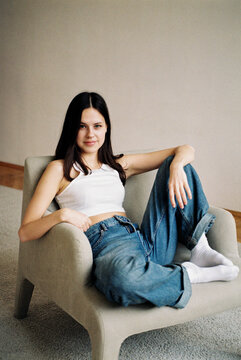 Woman relaxing in armchair in casual outfit  

