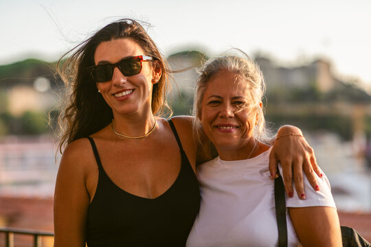Two Women Smiling Together at Sunset Near a Waterfront