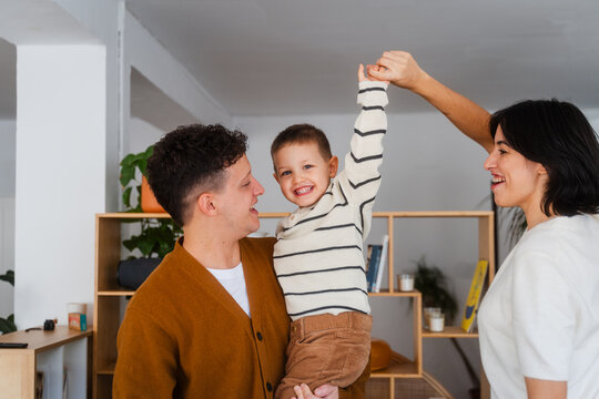 Parents enjoy time with their young son at home