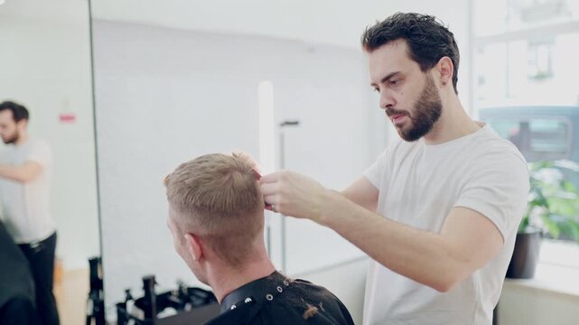 Professional barber cutting client's hair with electric clipper