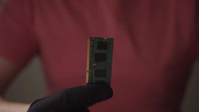 Person wearing glove carefully examining computer memory module, verifying integrity of hardware component and preparing for system upgrade or repair. Concept of desktop PC maintenance and service.