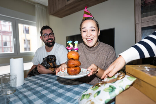 Family celebrating woman's 31st birthday with doughnut cake