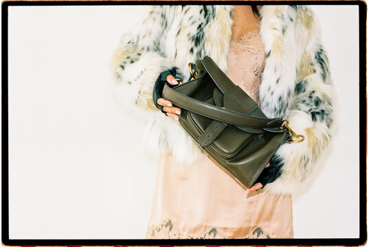Detail with fur jacket and green leather handbag