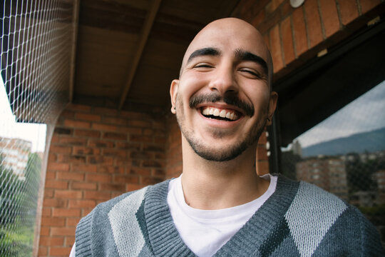 Smiling Man Enjoying His Time on a Balcony in the City