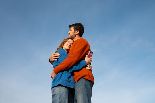 Couple hug phone blue sky
