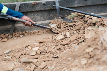 Offloading gravel and rocks from he back of a truck using a shovel © Dylan