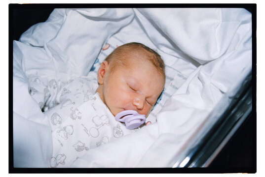 Newborn baby sleeping in a cozy bassinet