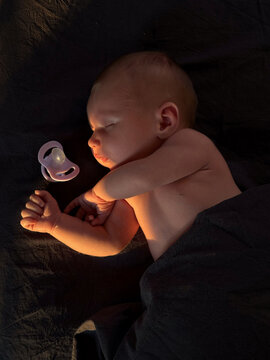 Baby peacefully sleeping with pacifier