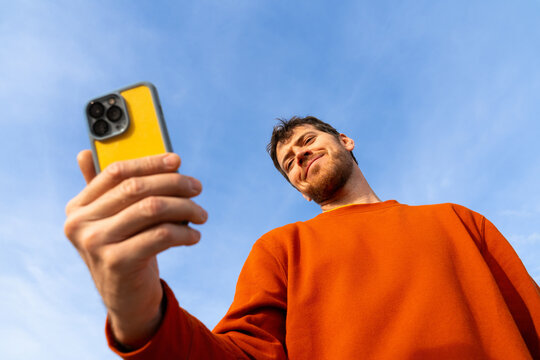 Man using phone clear blue sky