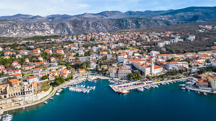 Fototapeta premium Aerial view of Kraljevica , Croatia, showcasing its vibrant marina, historic architecture, and the stunning Adriatic coast against a mountainous backdrop.