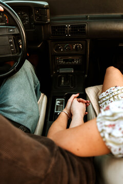Young couple holding hands in convertible car