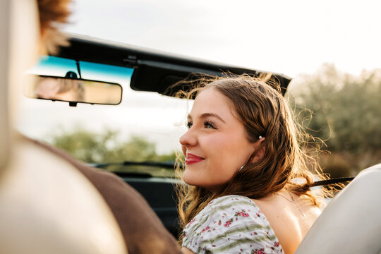 Close up of a young girl smiling in convertible 