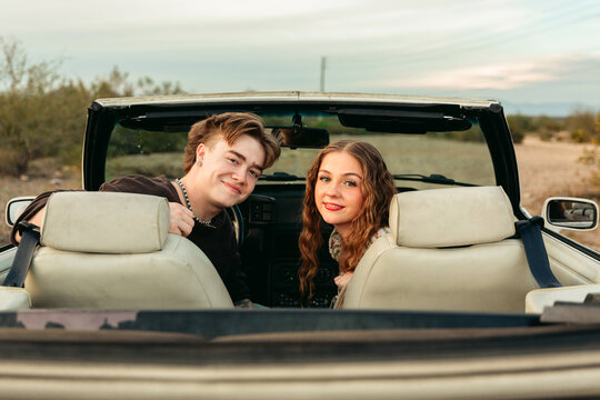 Man and woman looking back in convertible 