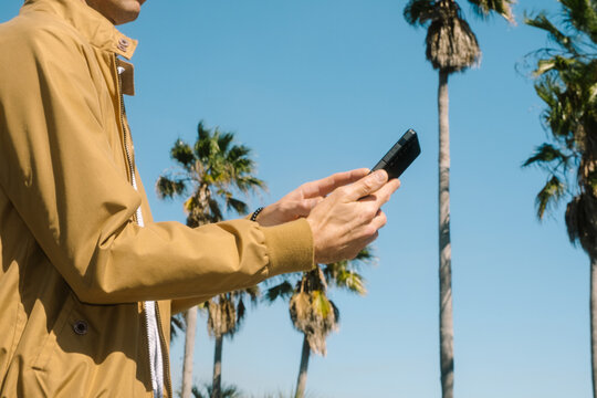 Man Using Mobile Phone on Sunny Day Outdoors