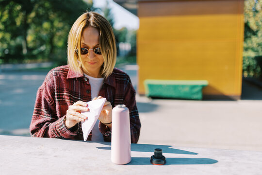 Woman Enjoying Her Time Outdoors While Preparing a Drink