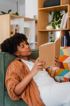 Woman cozy up with a good book at home