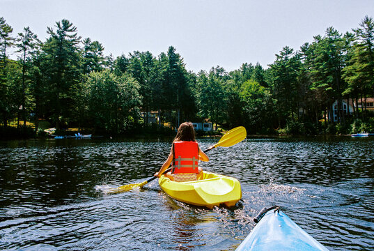 Child kayaking on a lake in Maine