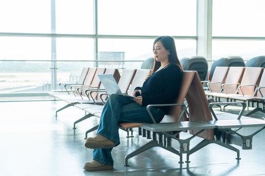 Chinese woman using laptop at airport