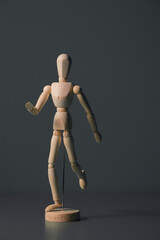Wooden Artist Mannequin Figure Walking Pose on Dark Background