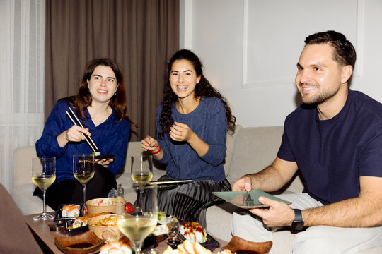 A group of young people are having dinner at home