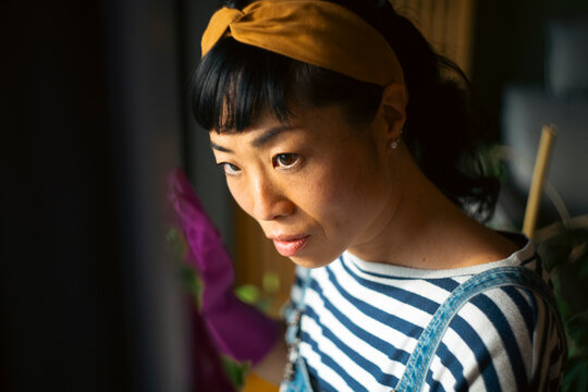 Asian woman concentrated cleaning home wearing headband