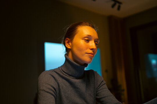 Young woman concentrating on computer screen light at home