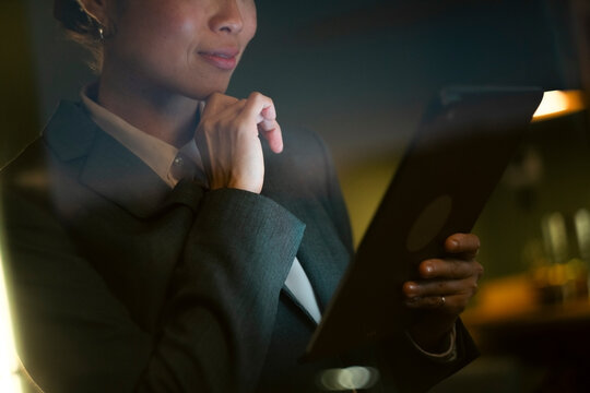 Asian businesswoman thinking holding tablet working online