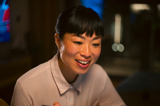 Asian woman smiling and working in office at night