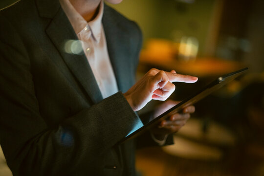 Business professional hand touching tablet screen at night
