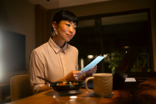 Woman working late night at home reviewing documents