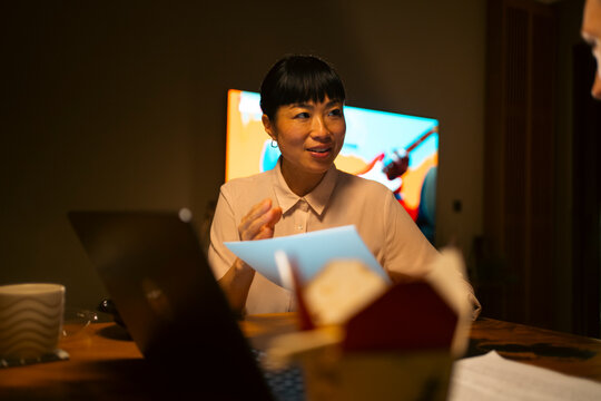 Asian businesswoman discussing project during late night meeting
