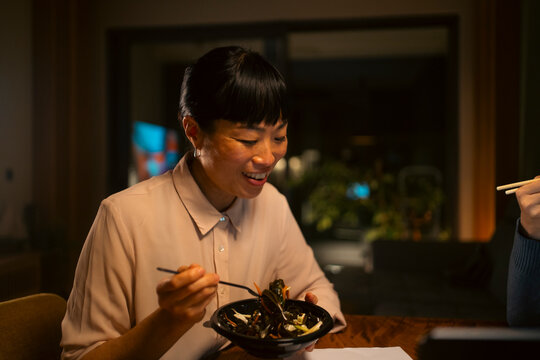 Young asian woman enjoying a takeout meal at night