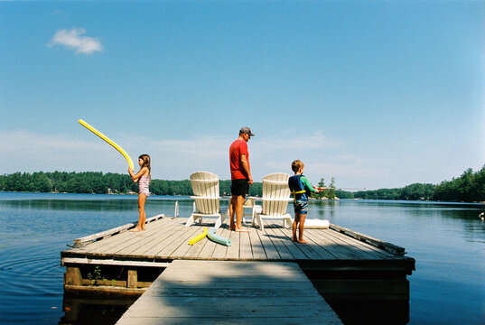 Family on the dock by the lake, summer vacation 