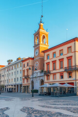 Obraz premium Rimini old town city square with clock tower and colorful buildings in Emilia Romagna, Italy at sunrise. Piazza Tre Martiri with Palazzo Brioli, Italian architecture. Vertical orientation