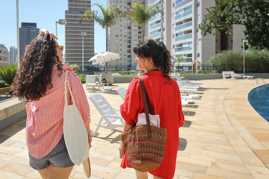 Friends talking and walking by the Poolside in a City Setting