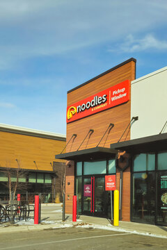 The exterior of a suburban Noodles & Company restaurant and pick-up parking space in winter (Minnesota, USA - Feb 21, 2026). Editorial Use Only.