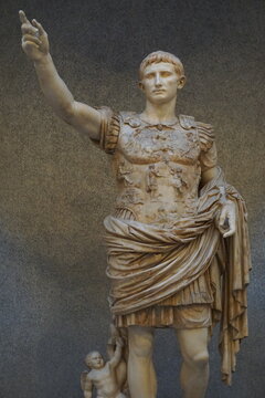 Vertical close up of an ancient Roman marble statue of Emperor Augustus in military armor giving a salute 