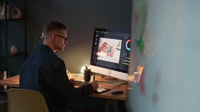 Professional retoucher sitting at desk, using computer to edit photo of brand new cosmetic products