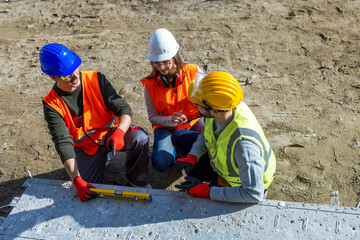 Male and female engineers walking on scaffolding while checking building plans and logbook data. © Mediteraneo