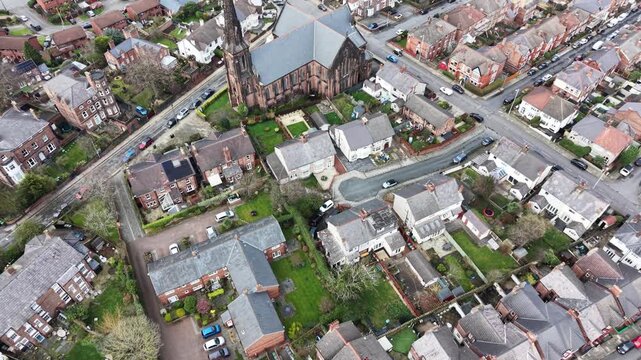 Drone shot of Birkenhead Christ Church with trees and houses in the background.