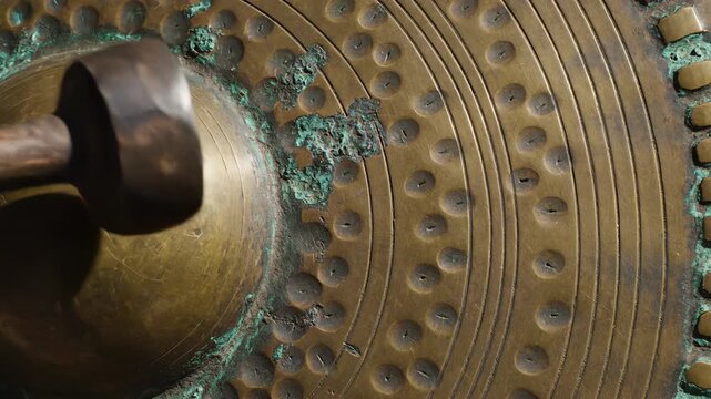 Close up of antique weathered bronze cymbal with hammered texture and patina detail