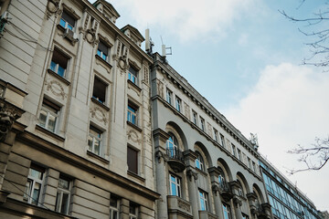 Fototapeta premium Historic urban facade with decorative elements and balconies creating architectural perspective in Belgrade.