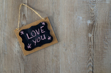 Love Note Written with Chalk on a Small Message Board on a Wood Wall