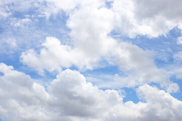 Obraz premium White cumulus clouds drift across a blue sky on a sunny afternoon. weather forecast, summer atmosphere, nature background.